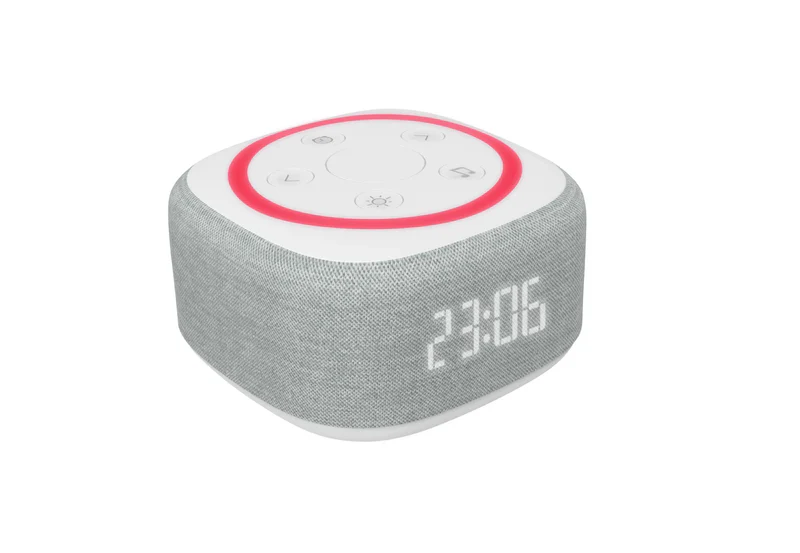 Couple sleeping peacefully with sunrise alarm on bedside table